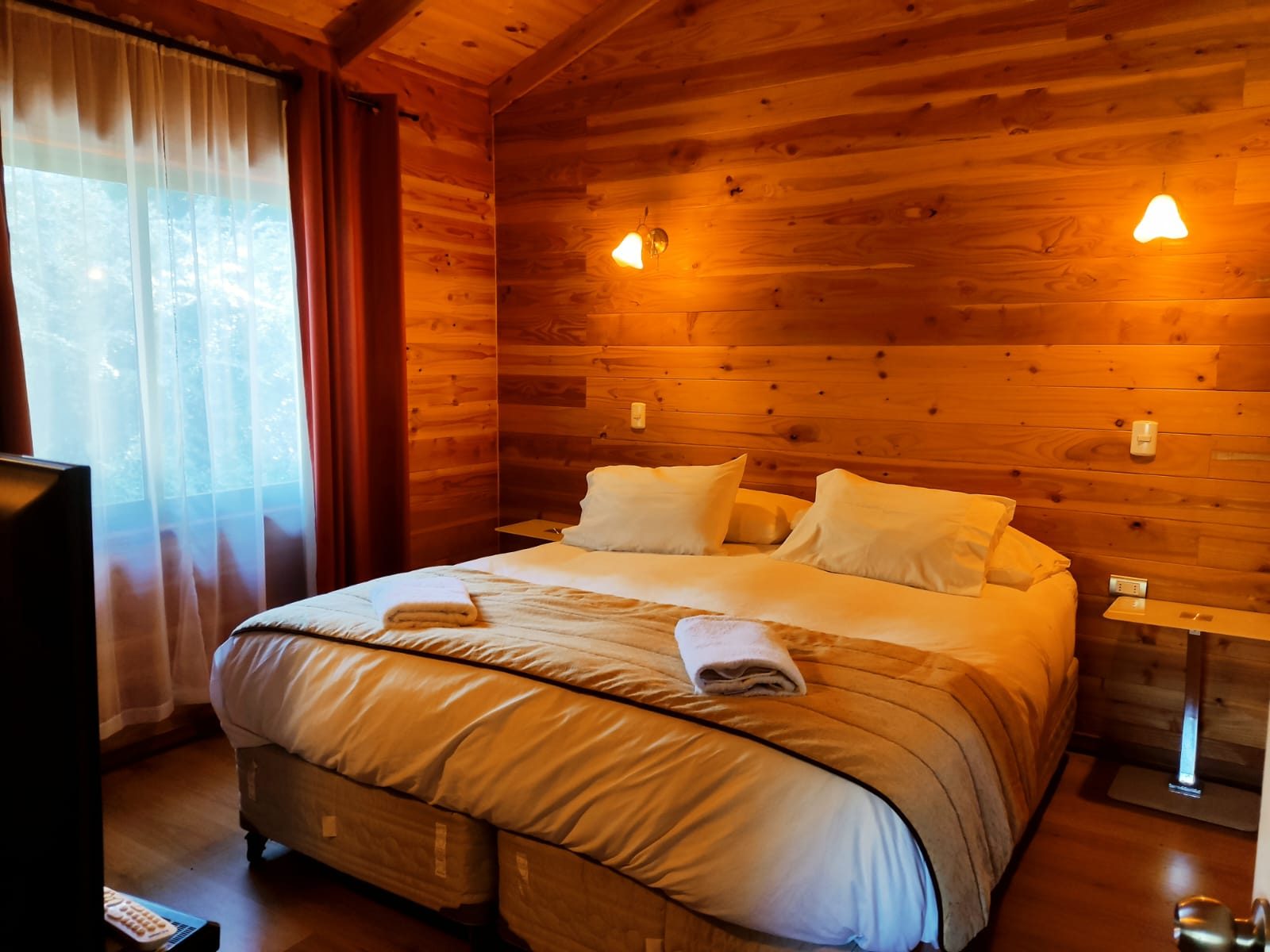 Habitación con cama grande y muros de madera